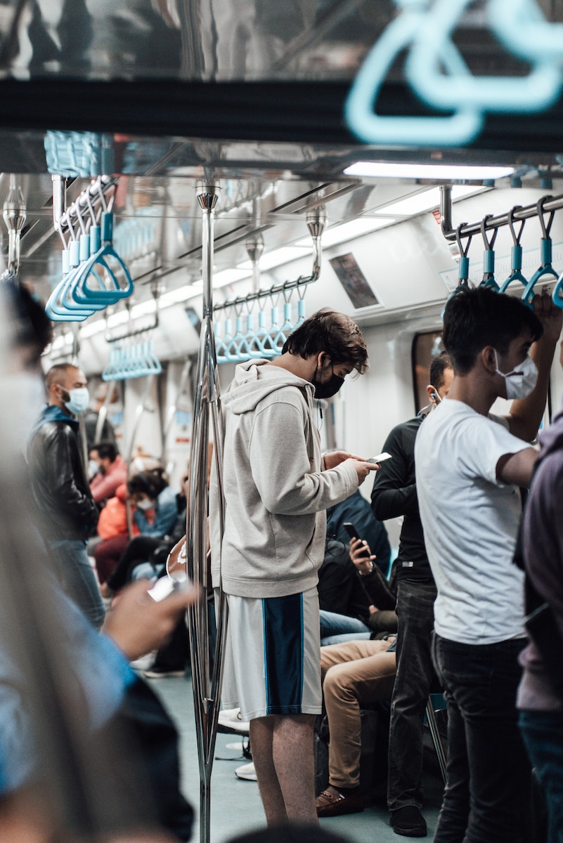 Crowded metro train with passengers in masks