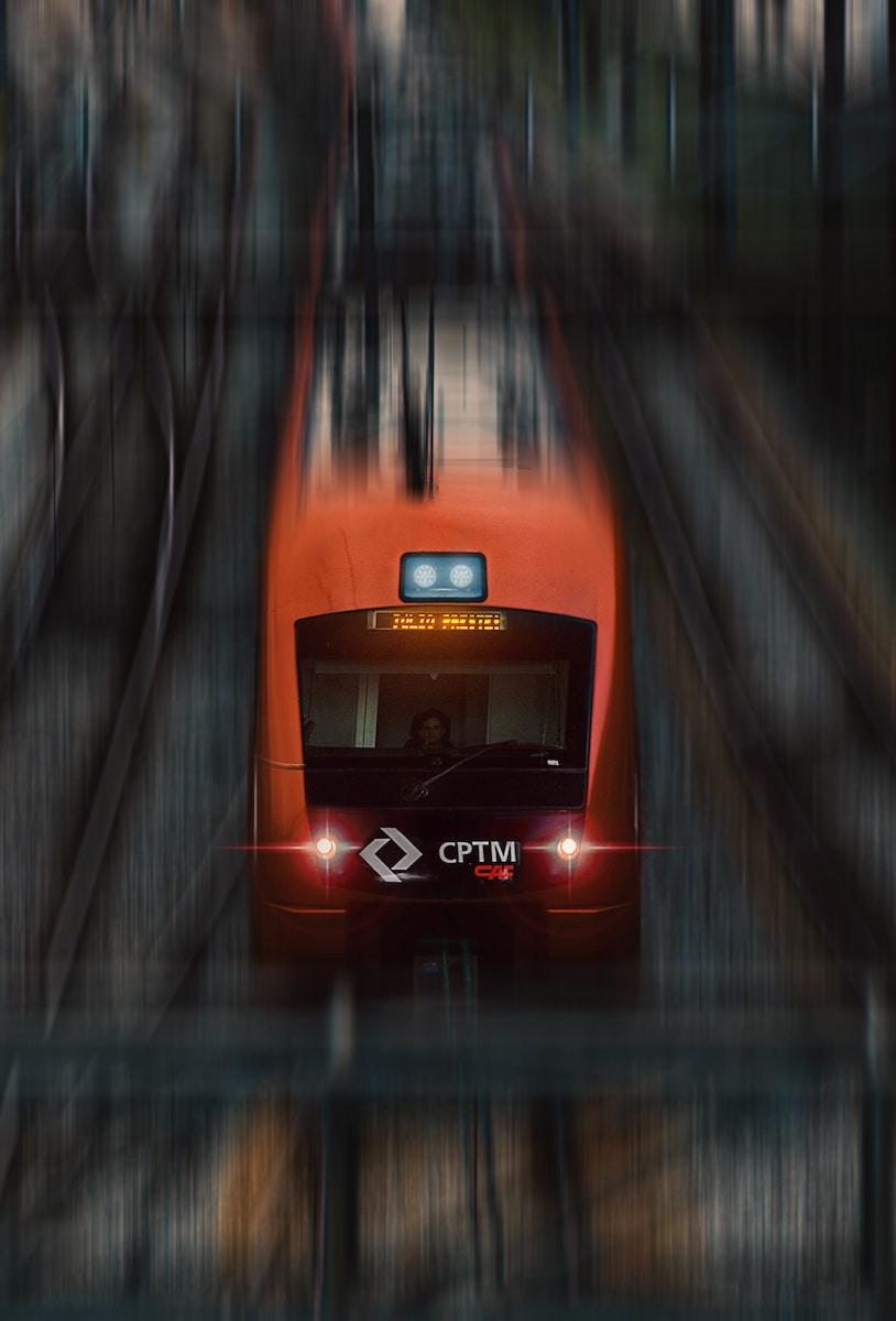 From above of red modern high speed train in motion on railway near platform on daytime