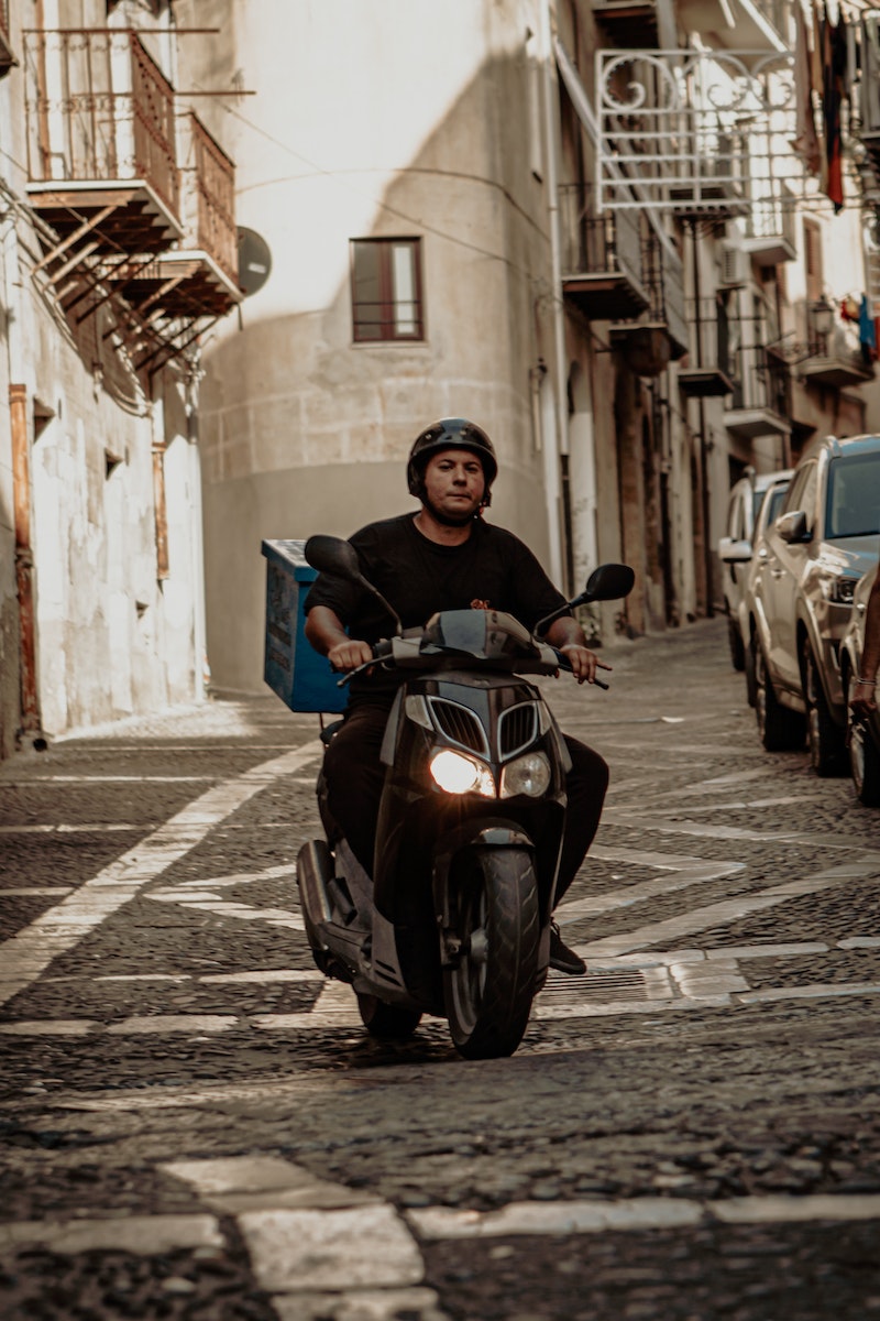 Man riding motorcycle on street in sunny day